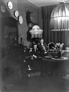853619 Afbeelding van het echtpaar E.J. Haanschoten en G.J. Haanschoten-Klaasen, in de woonkamer van het huis A.R. ...